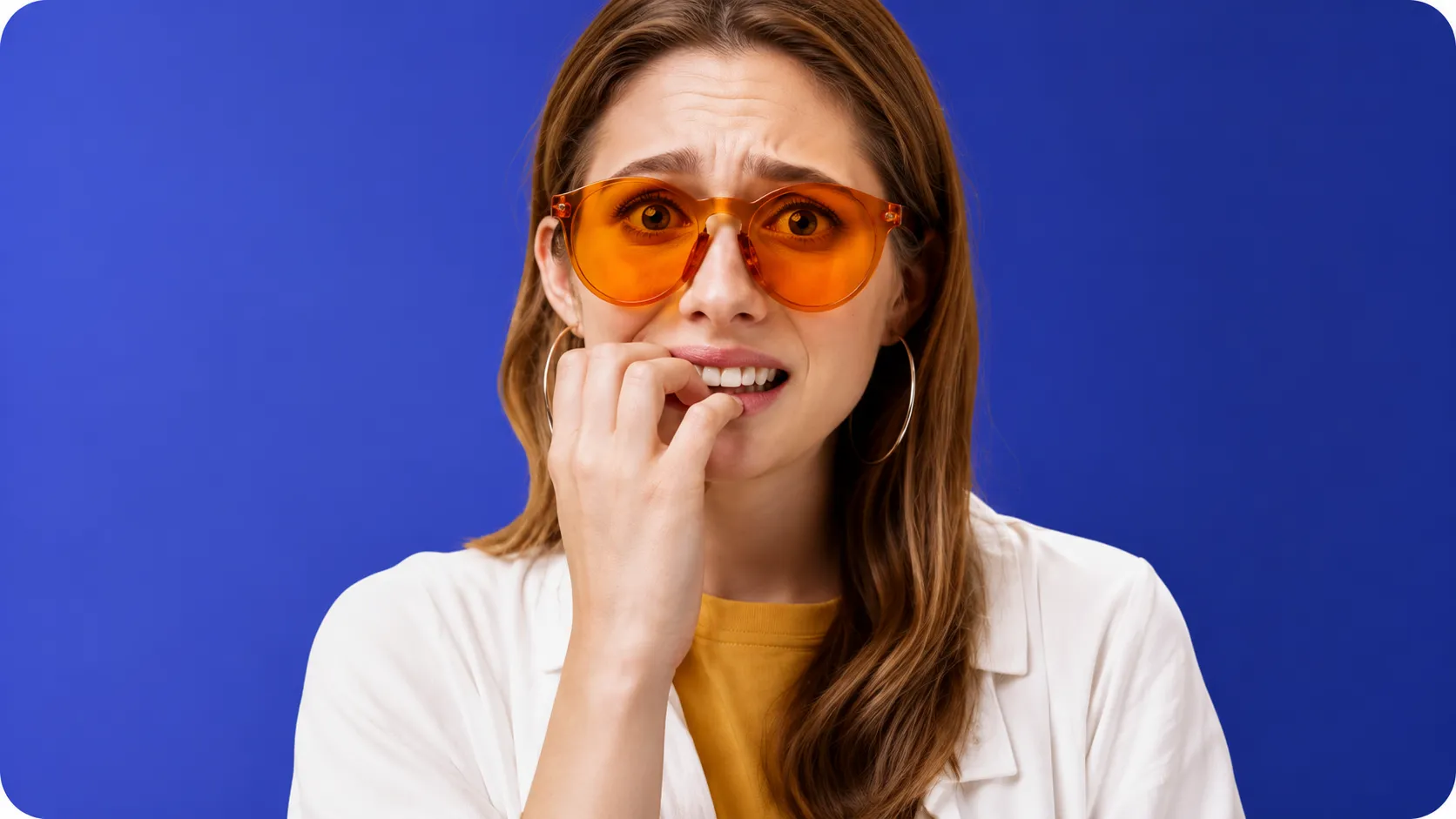 gestione-ansia-dentista-studio-dentistico-favro-cuneo Giovane donna dall'espressione preoccupata che porta una mano alla bocca, rappresentando ansia e paura del dentista.