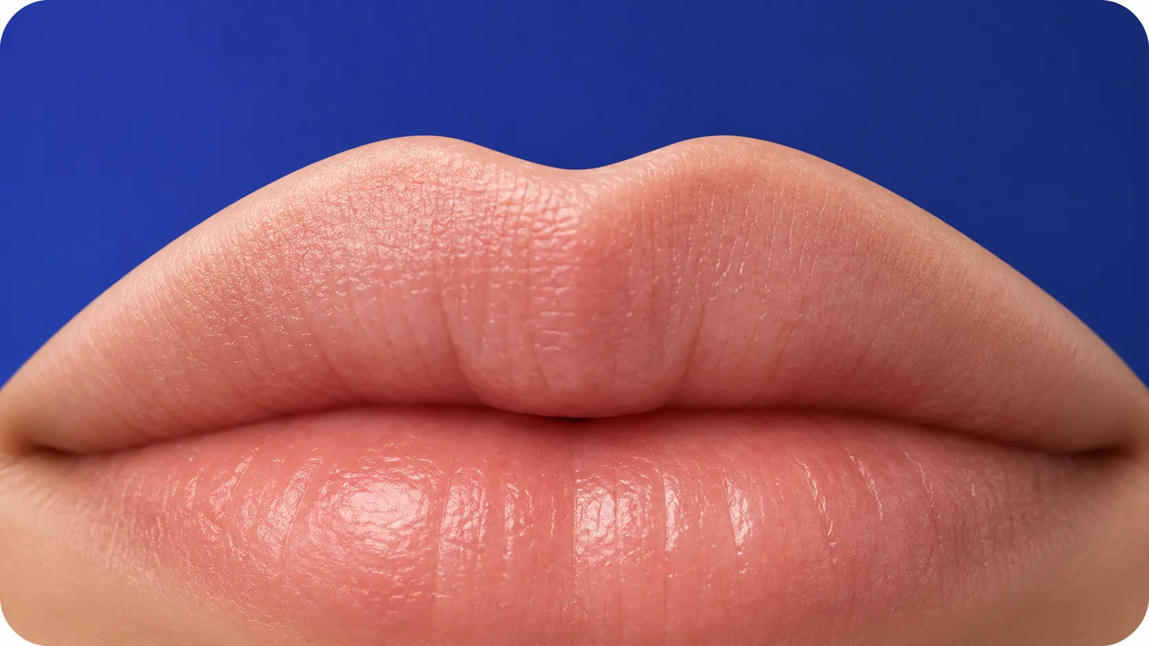 medicina-estetica-volto-labbra-studio-dentistico-favro-cuneo Primo piano di labbra dall'aspetto naturale su sfondo blu, immagine dedicata ai trattamenti di medicina estetica del volto
