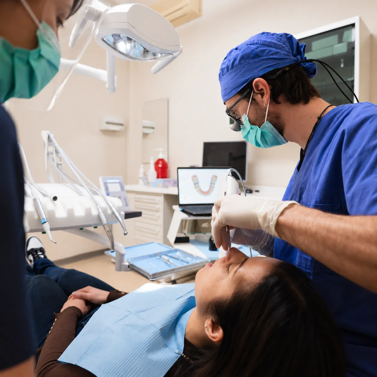 protesi-dentale-mobile odontoiatra dello studio dentistico favro mentre esegue una scansione digitale alle arcate dentali della paziente